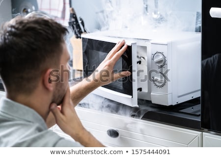 Stock foto: Man Looking At Fire Coming From Microwave Oven