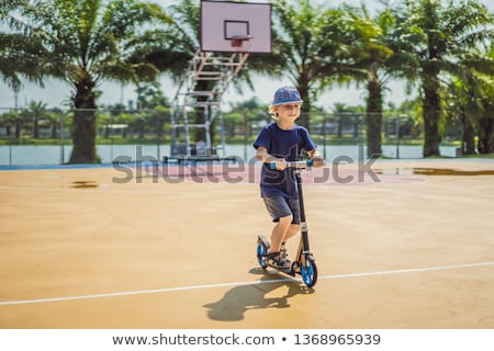 Stock fotó: Happy Child On Kick Scooter In On The Basketball Court Kids Learn To Skate Roller Board Little Boy