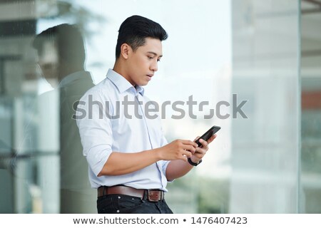 [[stock_photo]]: Checking His Mail Young Handsome Businessman Using His Touchpad While Standing In Office