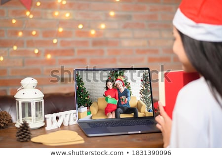 Stok fotoğraf: Cheerful Young Woman Wearing Santa Claus Hat