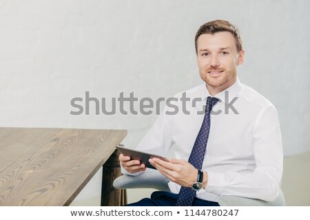 Сток-фото: Indoor Shot Of Handsome Male Freelancer Checks Notification On Modern Tablet Computer Connected To