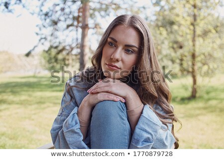 Stok fotoğraf: Young Lady With Hand On Knee And Chin