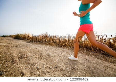 Stok fotoğraf: Young Woman On Her Evening Jog Along The Seacoast