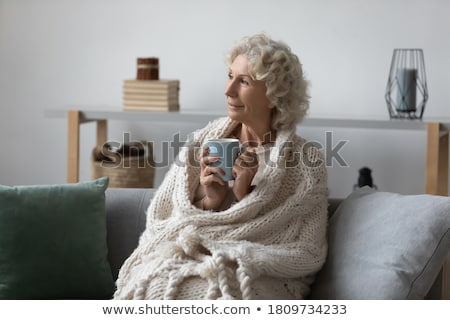 ストックフォト: Joyful Women Sitting On A Sofa With Cups In A Living Room