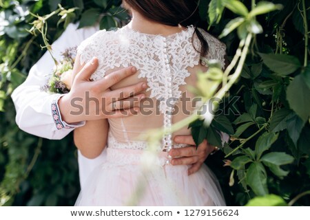 [[stock_photo]]: Couple Kissing Standing Outdoos Among Bushes