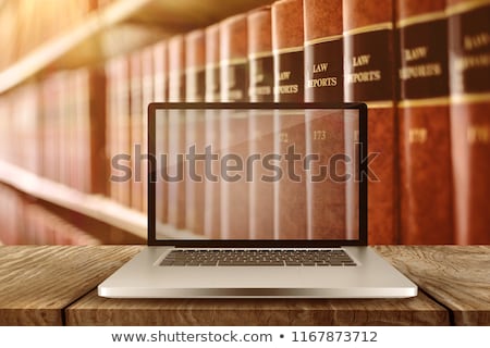 Foto d'archivio: Laptop With With Screen Against Close Up Of A Lot Of Law Reports