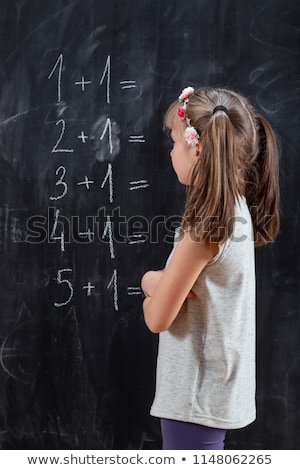 Foto stock: Girl Solving Mathematics On Chalkboard