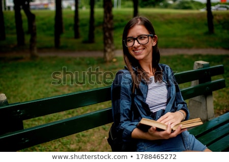 Zdjęcia stock: Smiling Young Woman Sitting On Bench Outdoors