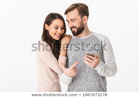 Stok fotoğraf: Image Of Optimistic Couple Using Mobile Phones Together Isolate