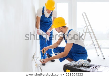 Stockfoto: Electrical Team Wiring A Room