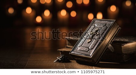 Zdjęcia stock: Precious Old Bible And Lit Candles In The Church