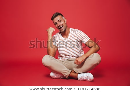 Stock fotó: Image Of Attractive Man 30s In Striped T Shirt Smiling While Si