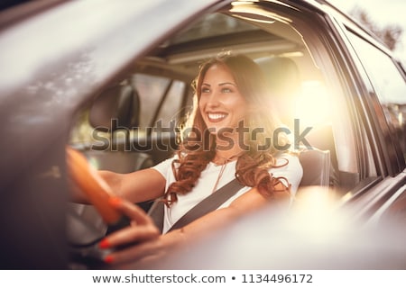 ストックフォト: Smiling Woman Driving A Car At Sunset