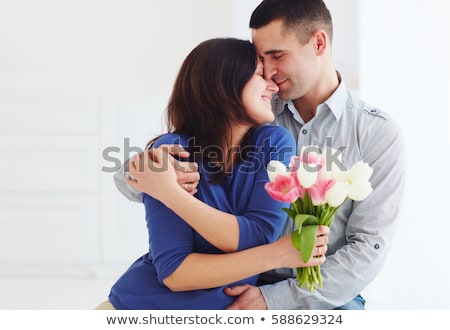 [[stock_photo]]: Ari · et · femme · tenant · des · fleurs · et · souriant