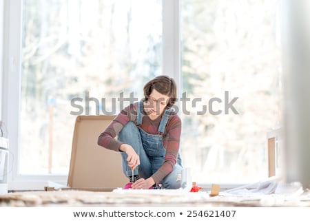 Stok fotoğraf: Caucasian Woman Using Screwdriver For Assembling Furniture