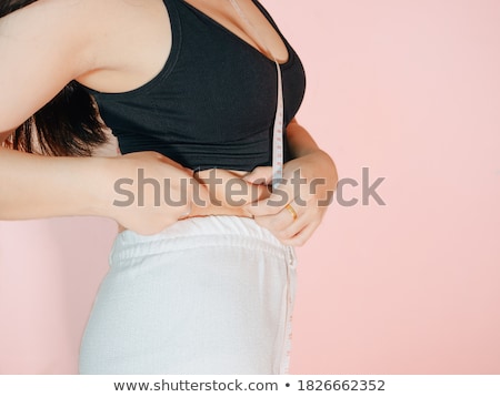 Foto d'archivio: Close Up Of Slender Woman Measuring Her Waist