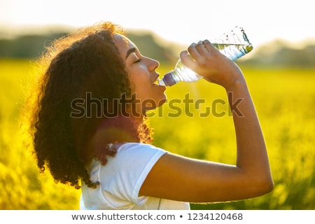 Stock fotó: Young Women In Yellow Sport Shirt Are Drinking Water At The Gym