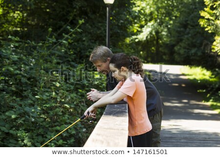 Young Girl Fishing Off Wooden Bridge ストックフォト © tab62