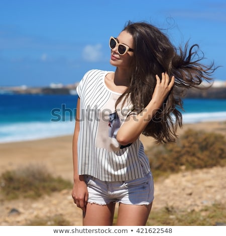 Сток-фото: Tanned Girl With Long Hair And Stylish Shorts On The Beach