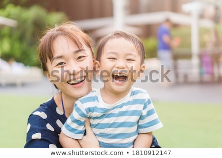 Foto d'archivio: Happy Mother Kissing Baby Outdoors Portrait