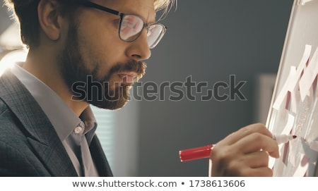 Stockfoto: Serious Businessman Holding A Marker And Writing