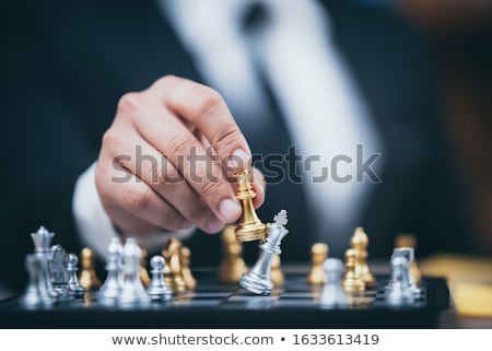 Foto stock: Hand Of Businessman Moving Chess Figure In Competition Board Gam