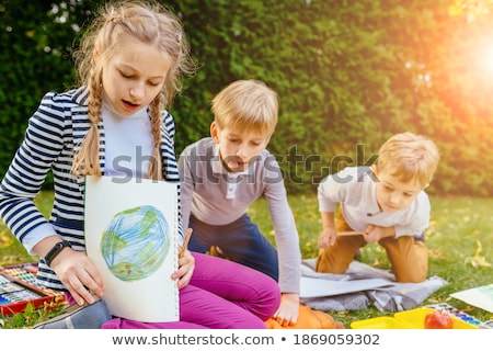 Foto stock: 3 Girls Sitting In Park Painting