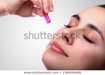 Сток-фото: Female Hand Squeezing Vitamin Capsule On Face