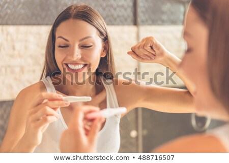 Stock fotó: Happy Pregnant Young Woman With Pregnancy Test Kit At Home