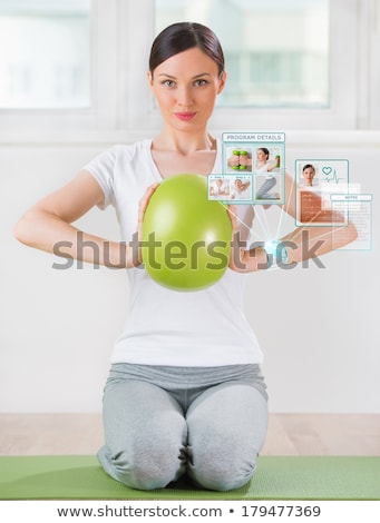 Stock fotó: Woman Doing Exercise With Ball Wearing Smart Wearable Device Wit