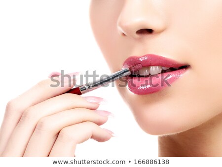 Foto d'archivio: Close Up Of Hand Applying Lipstick To Woman Lips