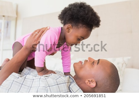 Foto stock: Father Playing With Adorable Baby Girl In Bedroom