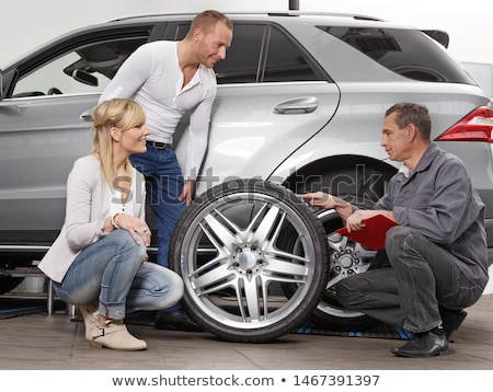 Foto d'archivio: Female Service Mechanic Changing The Front Tire Of A Car