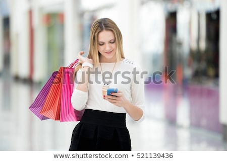 Сток-фото: Woman Look At Mobile Phone With Paperbags In The Mall While Enjo