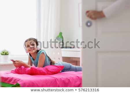 Foto stock: Girl Listening To Music And Mother Entering Room