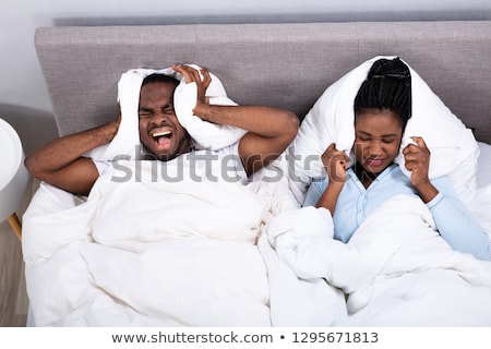 Foto stock: Irritated African Couple Disturbed By Noise On Bed