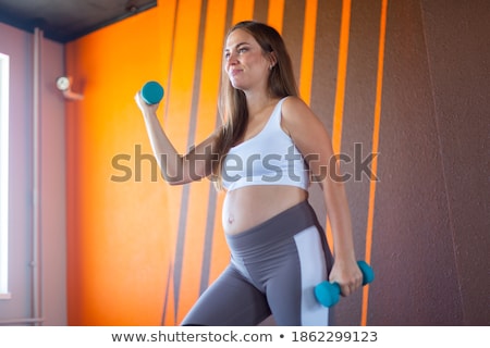 Stockfoto: Pregnant Girl Lifting Dumbbells Isolated On White