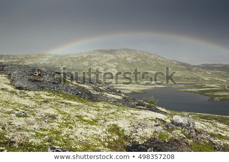 Foto stock: Dramatic Landscape With Beautiful Rainbow Over Arctic Meadows Mountain And Lake