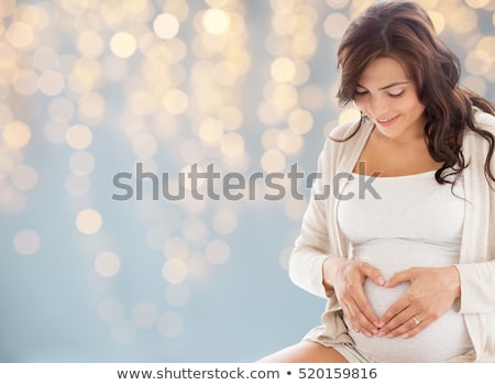 Foto d'archivio: Happy Pregnant Woman Making Heart Gesture