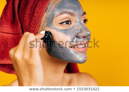 Foto d'archivio: Young Woman Applies A Magnetic Mask On Her Face With A Brush