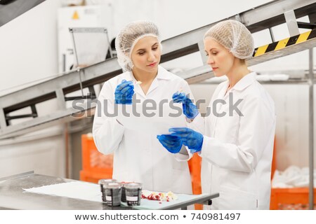 Foto stock: Women Technologists Tasting Ice Cream At Factory