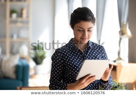 [[stock_photo]]: Pretty Young Smiling Student With Mobile Gadget Standing In Front Of Camera