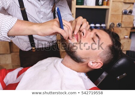 Zdjęcia stock: Young Bearded Man Getting Beard Shaving By Hairdresser