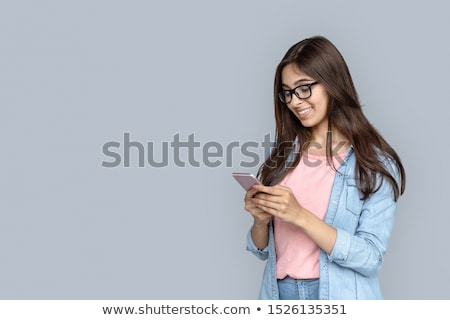 商業照片: Young Lady Standing And Holding A Phone With Copy Space