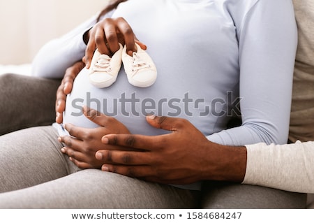 Foto d'archivio: Pregnant Woman Cuddling Belly In Bedroom At Home