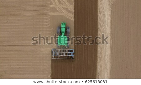 Stockfoto: Aerial View Of Harvest Field With Agricultural Machinery Carrying Out Work In The Field