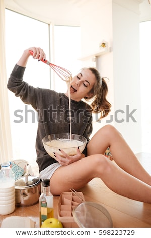 Stockfoto: Beautiful Woman Tasting Liquid Dough For Baking Muffins