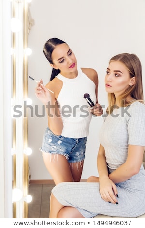Stockfoto: Young Makeup Artist Doing Makeover To Pretty Model