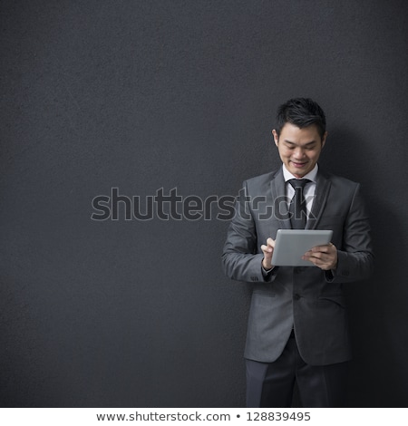 Сток-фото: Young Successful Businessman Using Touchpad On Background Of Colleague