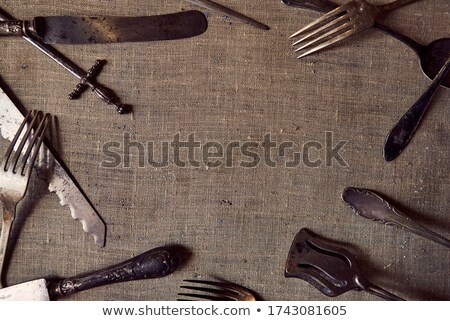 Stockfoto: Composition Of Metal Vintage Knives With An Ornament And Old Forks With Wooden Handles On A Gray Bac